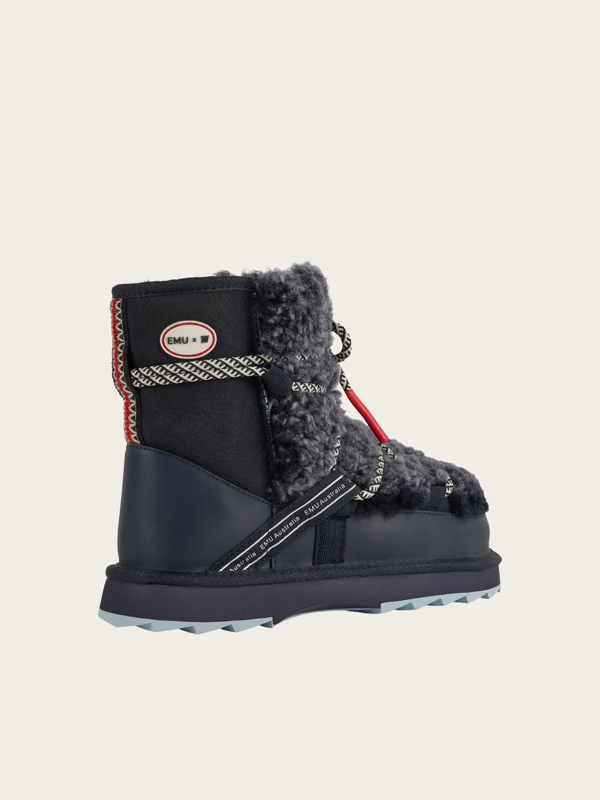 Side view of the EMU x WN Blurred Teddy winter boot by EMU, featuring navy and gray colors, plush teddy sheepskin lining, red and white accents, rope laces, and a rugged sole, showcased against a plain light background.