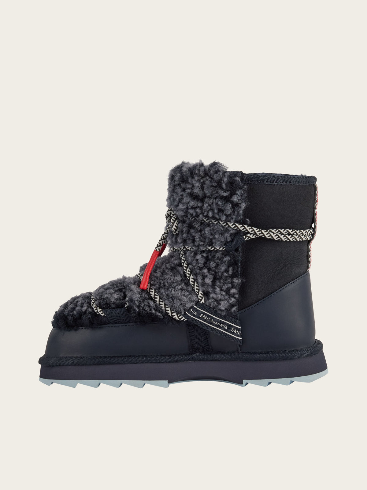 The EMU x WN Blurred Teddy by EMU showcases Nordic design with its single black winter boot featuring plush gray teddy sheepskin, black-and-white rope laces, a red accent tag, and a chunky sole, set against a plain light background.