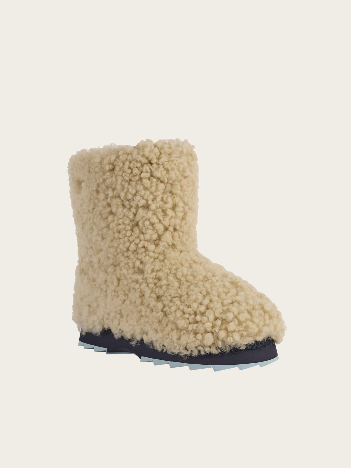 A single EMU x WN Sharky Lo Teddy boot by We Norwegians, featuring an ankle-high design with a textured, fluffy cream-colored teddy sheepskin exterior and a thick black rubber sole, displayed on a plain light background.