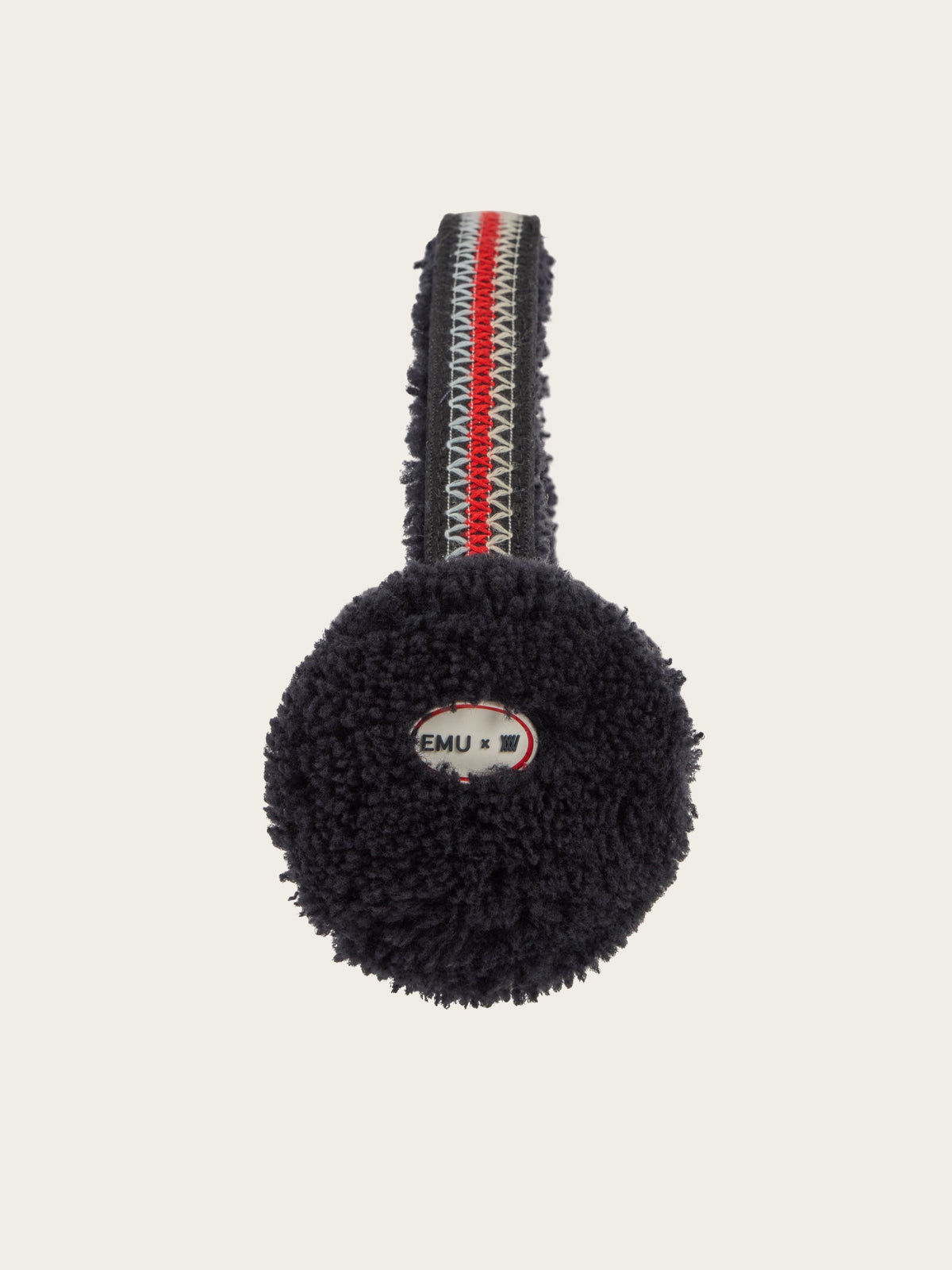 The EMU x WN Angahook Teddy Earmuff by We Norwegians is shown from the front, featuring round, fuzzy black earmuffs with a teddy finish and a red, white, and blue striped headband. The inner label is partially visible, displaying text alongside a small flag motif.