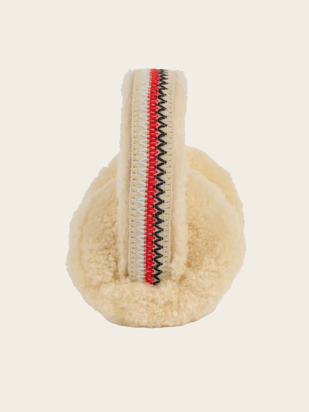 The EMU x WN Angahook Teddy Earmuff by We Norwegians features a cream-colored, plush teddy finish and a headband accented with red, white, and black zigzag stitching, displayed from the front against a plain background.