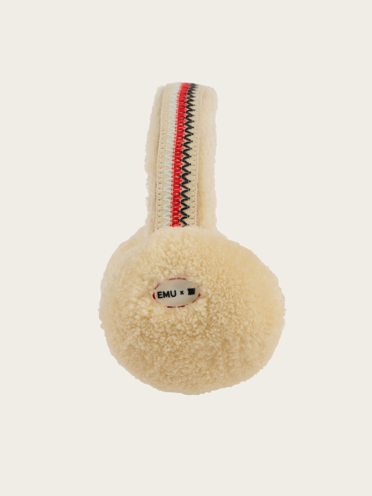 The EMU x WN Angahook Teddy Earmuff by We Norwegians features plush beige sheepskin ear covers with a cozy teddy finish and a striped red, white, and black headband. The earmuffs are accented with a small label that reads “EMU x.”.
