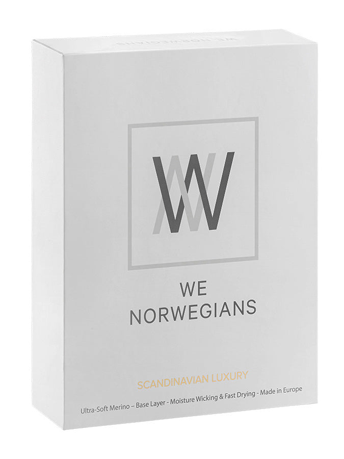 A photo shows a white retail box featuring the "We Norwegians" branding. The logo includes stylized "WN" initials within a square. The box highlights product features like the "Sno Merino 3/4 Pants Men," described as a "Scandinavian Luxury base-layer" made from "Ultra-Soft Merino Wool," offering a "3/4 Length Long Johns," and is proudly "Made in Europe.