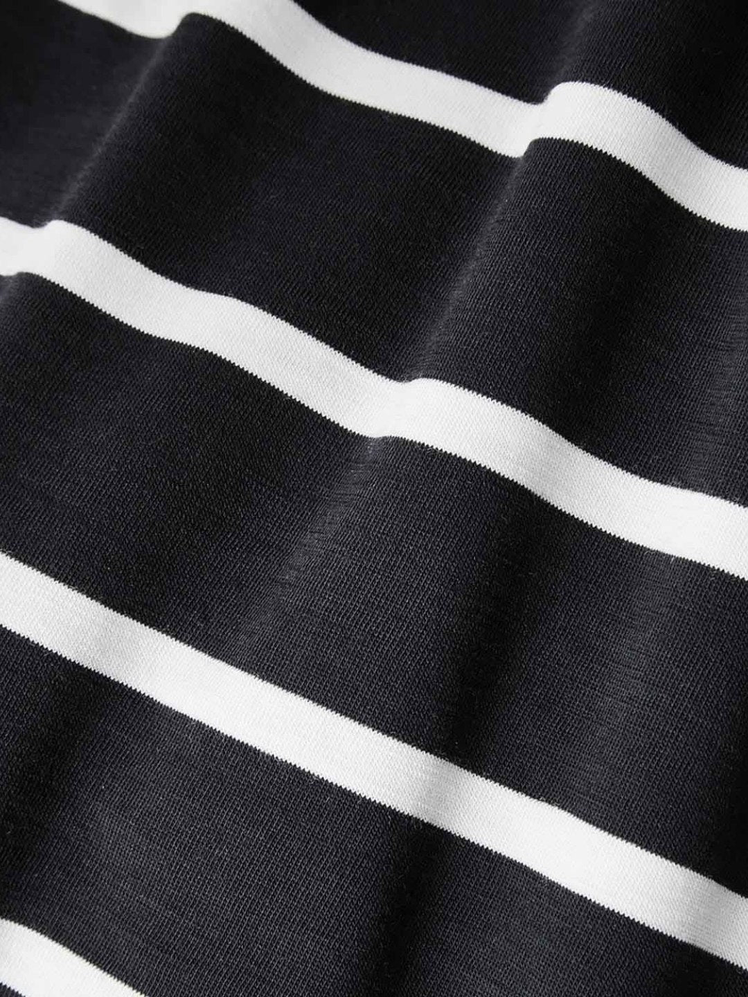 A close-up of the Kragero Tee Men Navy by We Norwegians reveals its high-quality Tencel fabric featuring white horizontal stripes. The texture is visible, displaying slight folds and a smooth surface. The alternating navy and white stripes create a bold, classic pattern perfect for a stylish base-layer.