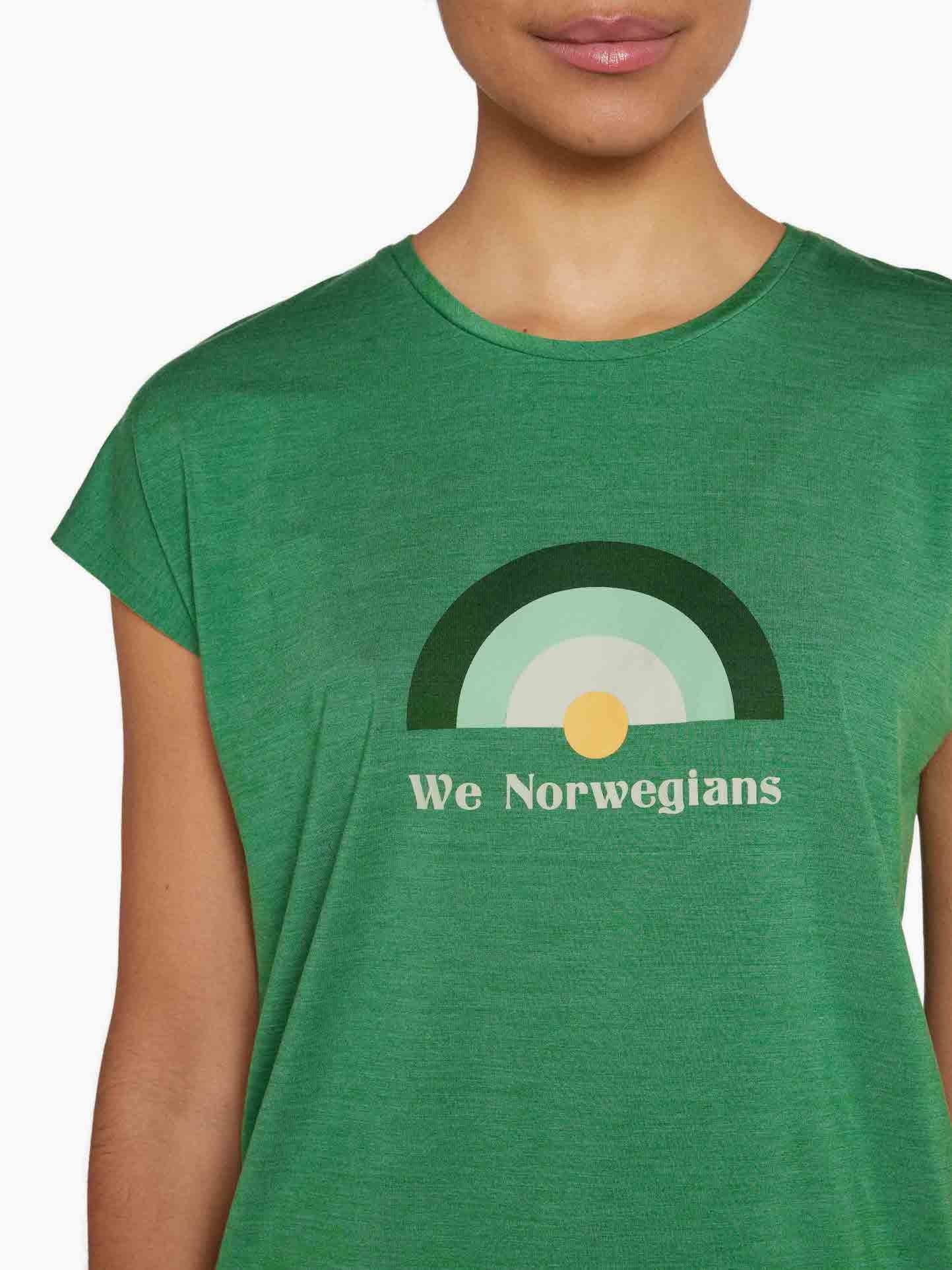 A person in summer attire wears the Rainbow Sleeveless Top Women Green by We Norwegians, showcasing a rainbow-like design with a gradient arch in green shades and a yellow circle at the bottom center. The words "We Norwegians" are printed below the graphic, and their face is partially visible.