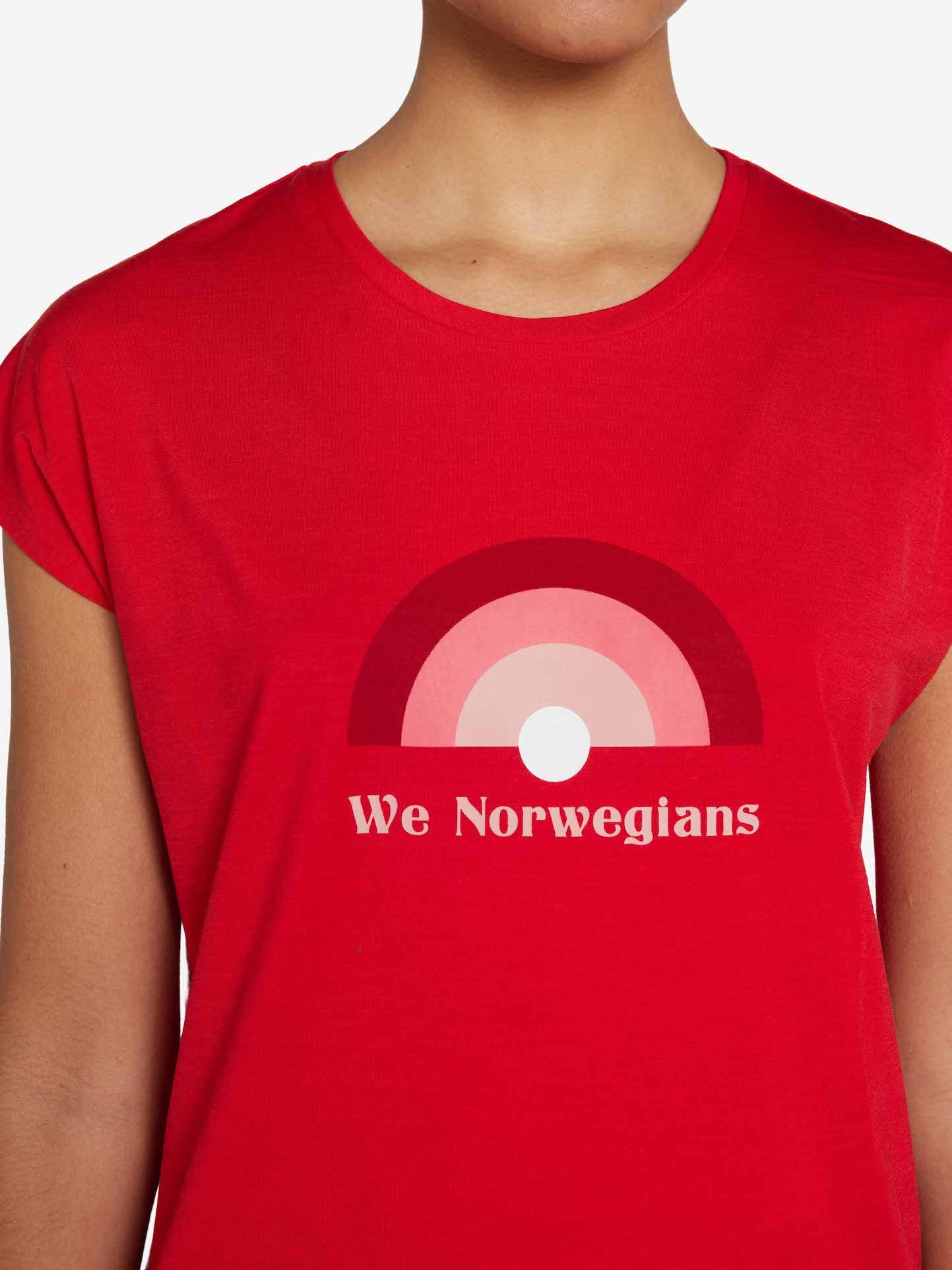 A person wearing the Rainbow Sleeveless Top Women Red by We Norwegians, featuring an abstract design of concentric semi-circles in various shades of red and pink with a small white circle at the bottom center. Below the design, text reads "We Norwegians." The Merino Wool fabric ensures ultimate comfort. The person's face is not visible.